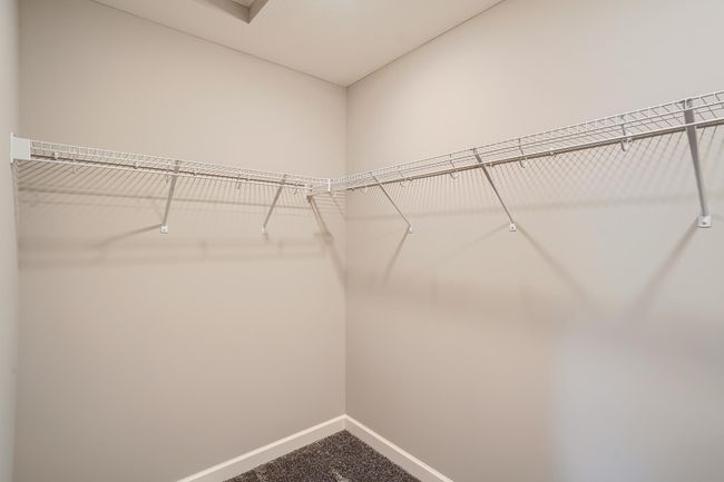 Photo is of the model. Spacious primary bedroom walk-in closet. | Image 15