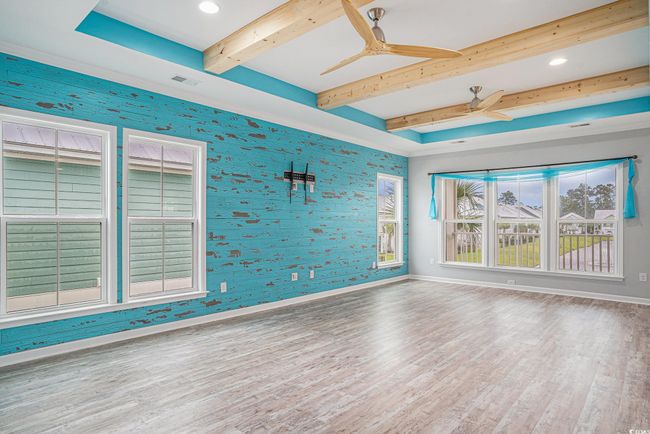 Unfurnished room with wood finished floors, ceiling fan, beam ceiling, wallpapered walls, and recessed lighting | Image 6