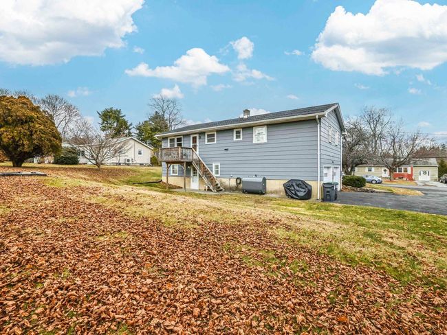 Rear view of house with a lawn and a wooden deck | Image 32
