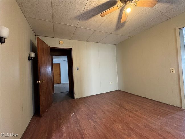 Spare room with a ceiling fan, a drop ceiling, and wood finished floors | Image 15
