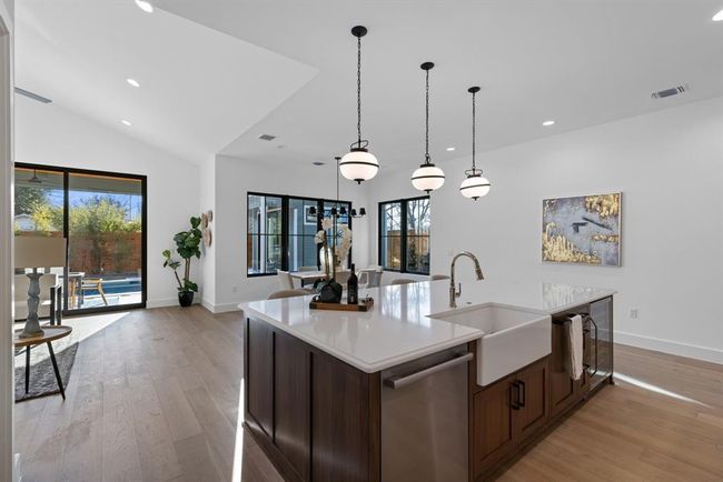 Kitchen featuring dishwasher, a sink, light countertops, light wood finished floors, and recessed lighting | Image 19