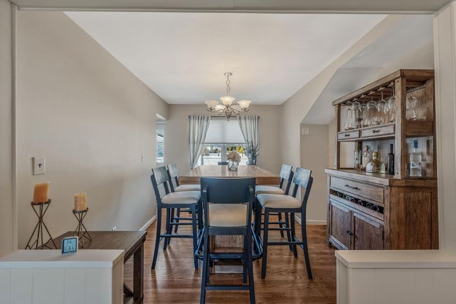 Dining space with dark hardwood / wood-style floors and a chandelier | Image 7