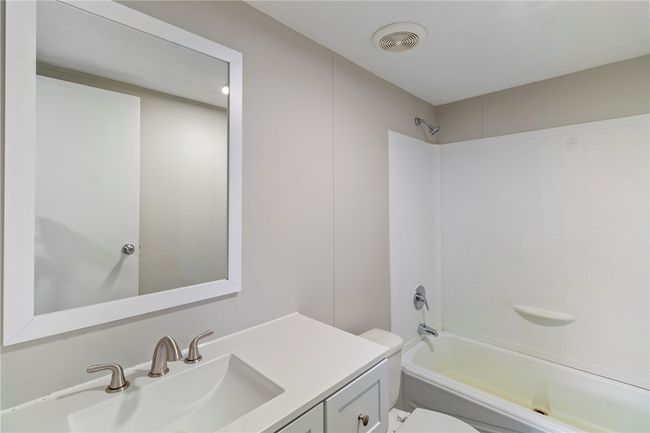 Bathroom featuring shower combination, toilet, vanity, and visible vents | Image 11