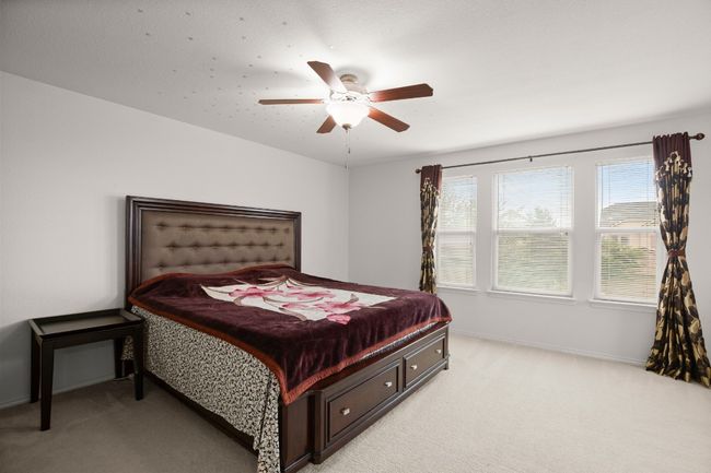 Bedroom featuring light colored carpet and ceiling fan | Image 14