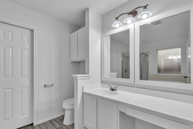 Bathroom featuring vanity and a shower with door | Image 19
