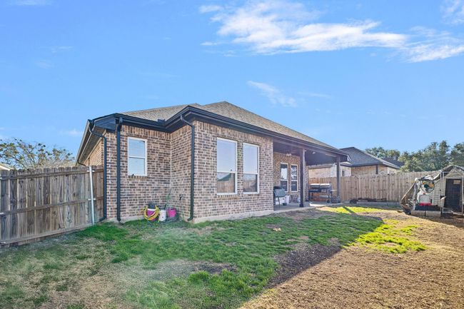 View of home's exterior featuring a patio area, a yard, brick siding, and a fenced backyard | Image 31