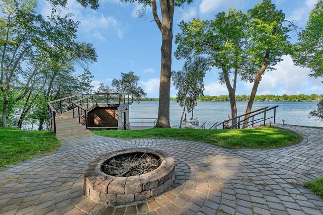 Enjoy stunning lakeside views while relaxing by the firepit, the perfect spot for unwinding and taking in the peaceful surroundings. | Image 21