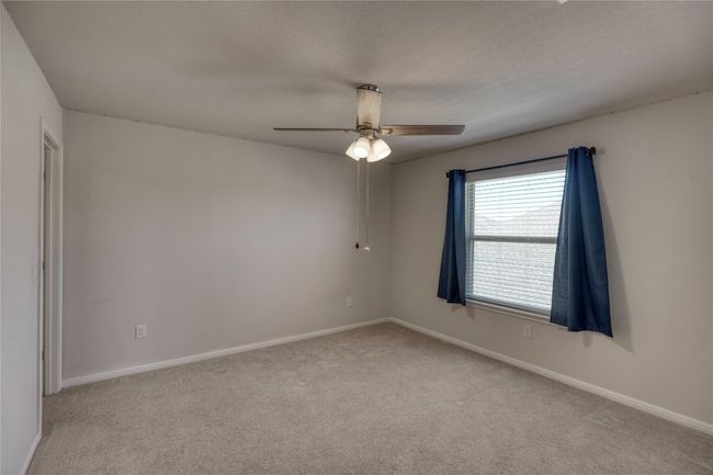 Unfurnished room featuring light colored carpet, baseboards, and a ceiling fan | Image 34