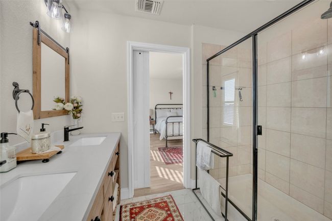 Full bathroom with a double vanity sink, toilet, marble finish floor, and a walk-in shower | Image 19