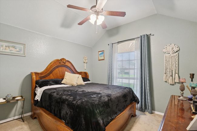 Third bedroom with lofted ceiling, light colored carpet, baseboards, and ceiling fan | Image 19