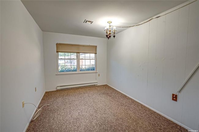 Empty room featuring baseboard heating, carpet flooring, and an inviting chandelier | Image 7