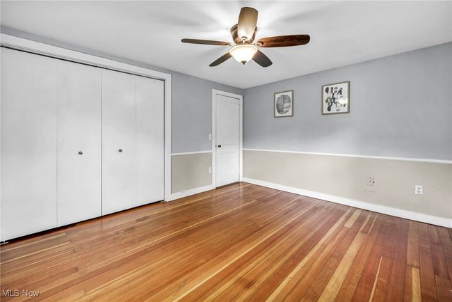 Unfurnished bedroom with a closet, hardwood flooring, and ceiling fan | Image 24