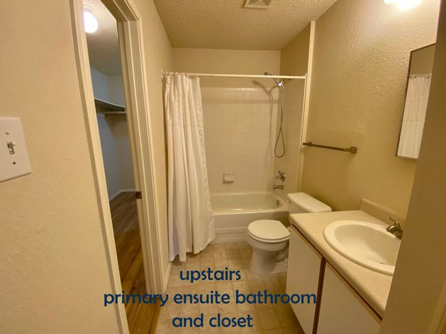 Bathroom featuring tile patterned flooring, shower / bath combo, toilet, vanity, and a textured ceiling | Image 19