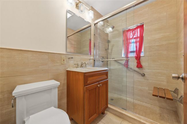Bathroom featuring vanity, a stall shower, tile walls, and tile patterned floors | Image 17