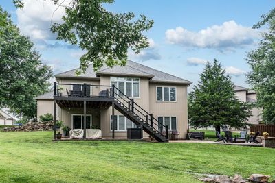 Rear view of house with a lawn, central AC unit, a patio area, and a deck | Image 2