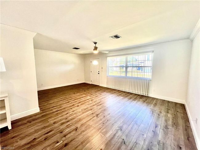 Living room featuring crown molding, LUXURY VINYL PLANK FLOORS. | Image 13
