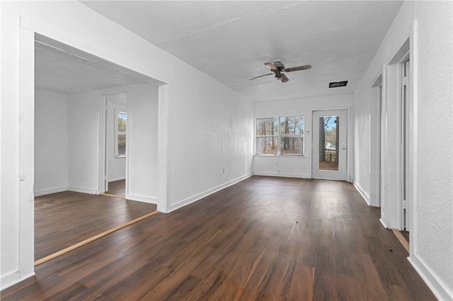 Empty room featuring ceiling fan and dark wood finished floors | Image 22