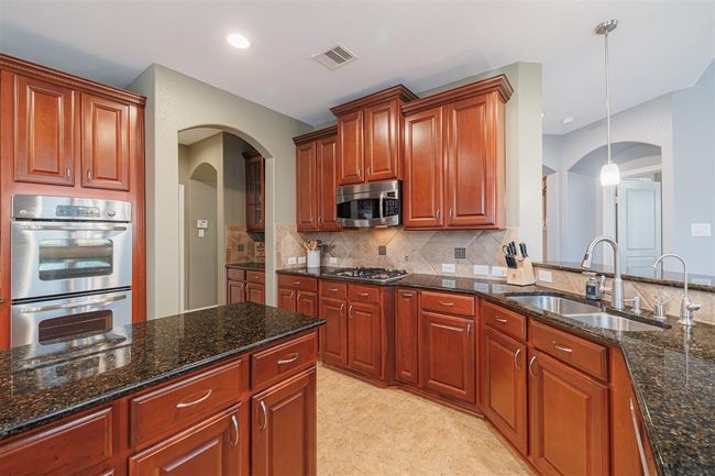 Kitchen also features double ovens and an undermount sink. | Image 16
