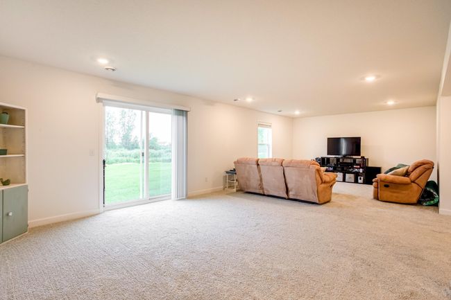 Bright lower level features sliding glass doors that open to lush backyard views and natural light. | Image 32