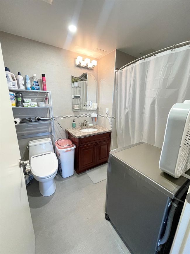 Full bathroom with vanity, a shower with curtain, and toilet | Image 8