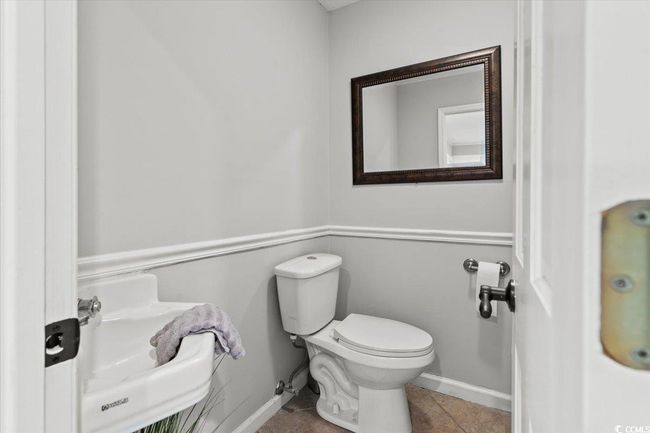 Bathroom with toilet, tile patterned floors, and baseboards | Image 17