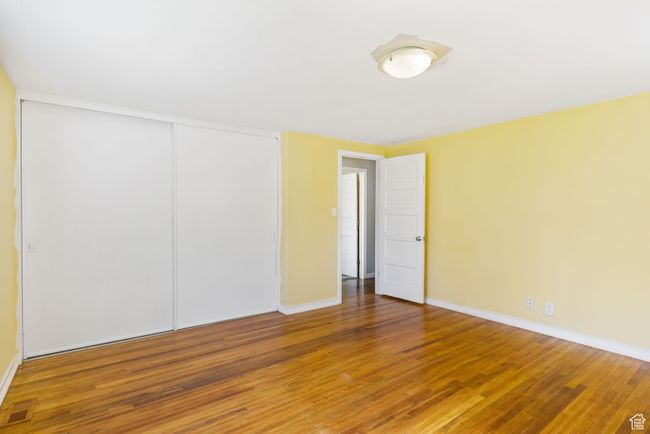 Empty room with visible vents, baseboards, and wood finished floors | Image 34