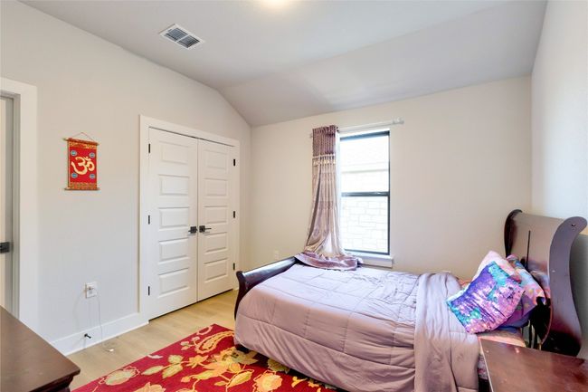 Bedroom featuring a closet, visible vents, baseboards, light wood-style floors, and vaulted ceiling | Image 15