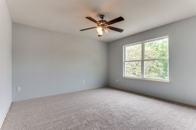 Carpeted spare room featuring a ceiling fan and baseboards | Image 39