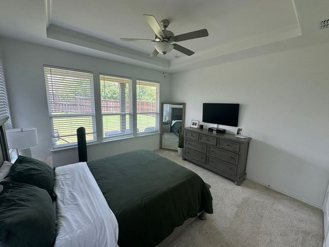 Bedroom with a raised ceiling, light carpet, a ceiling fan, and ornamental molding | Image 7