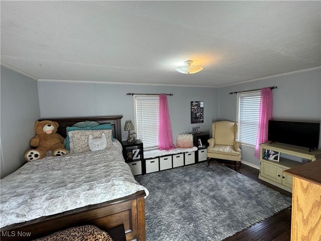 Bedroom with crown molding and dark wood-type flooring | Image 24