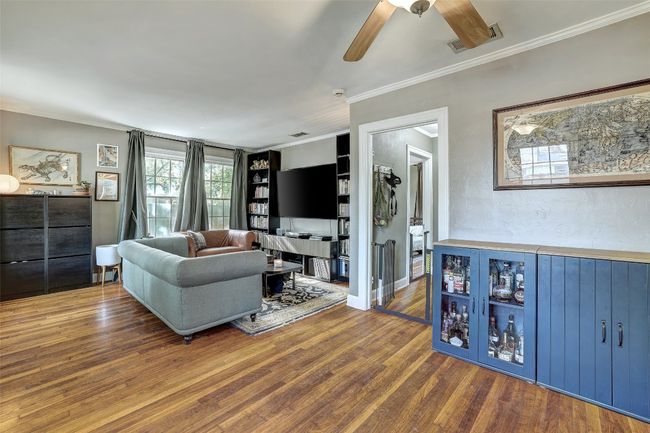 Living room featuring ceiling fan, ornamental molding, wood finished floors, and visible vents | Image 4