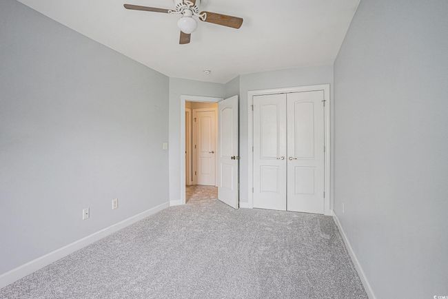 Unfurnished bedroom featuring carpet flooring, a closet, and ceiling fan | Image 14