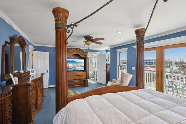 Bedroom featuring a wall mounted AC, access to outside, baseboard heating, french doors, and crown molding | Image 27