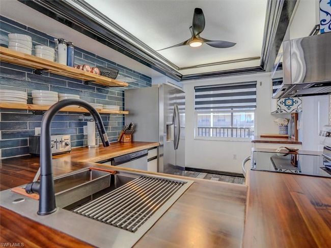 KITCHEN FEATURES: FULL-HEIGHT SUBWAY TILE BACKSPLASH, OPEN SHELVING; ACACIA WOOD COUNTERTOPS; LIGHTED TRAY CEILING; MODERN CEILING FAN W/LIGHT; STAINLESS STEEL SINK W/HIGH ARC FAUCET | Image 12
