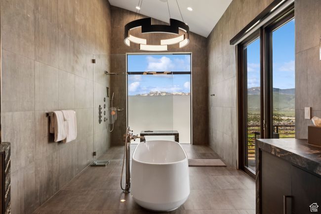 Bathroom featuring tile walls, a soaking tub, walk in shower, vanity, and tile patterned floors | Image 32