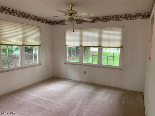 Unfurnished room featuring plenty of natural light, light carpet, and a ceiling fan | Image 26