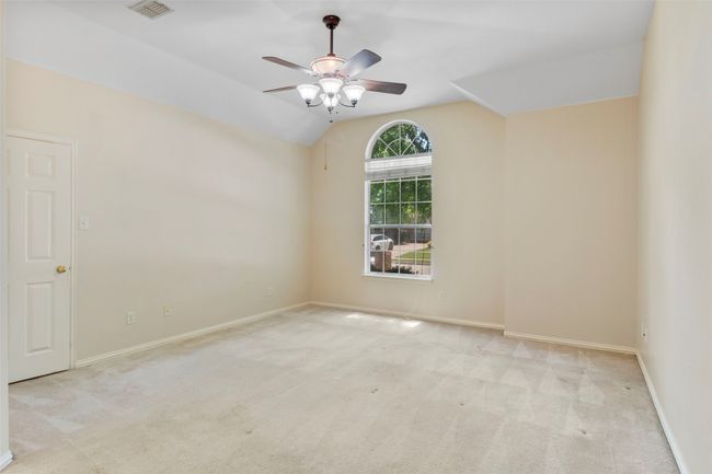 Carpeted empty room with a ceiling fan, baseboards, and vaulted ceiling | Image 10