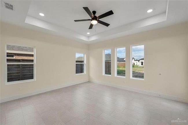 Spare room featuring a tray ceiling, recessed lighting, a ceiling fan, baseboards, and light tile patterned floors | Image 13
