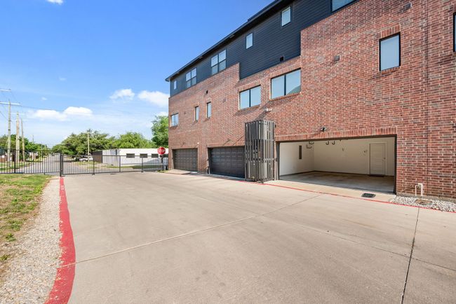 View of building exterior with fence and an attached garage | Image 37