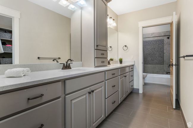 Connected bathroom featuring tile patterned flooring, a sink, double vanity, and toilet | Image 23