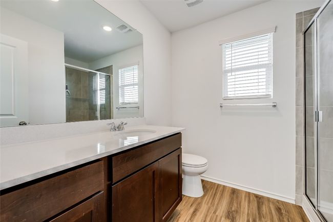 Garage apartment bathroom featuring vanity, a stall shower, wood finished floors, and recessed lighting | Image 37