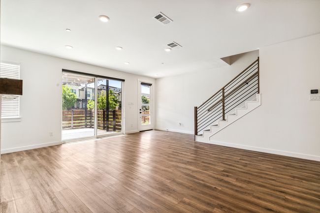 Unfurnished room with stairway, wood finished floors, baseboards, and recessed lighting | Image 10