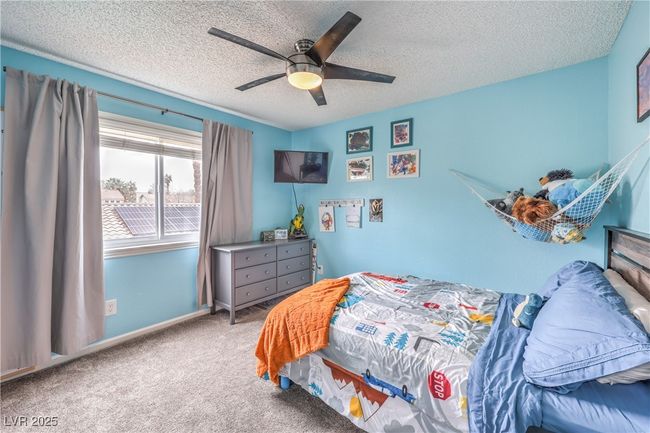 Bedroom featuring baseboards, a textured ceiling, ceiling fan, and carpet floors | Image 33