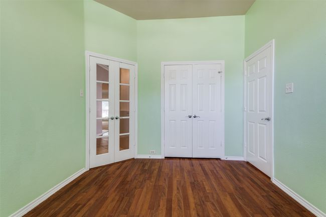 Unfurnished bedroom with french doors, dark wood-style floors, and a closet | Image 18
