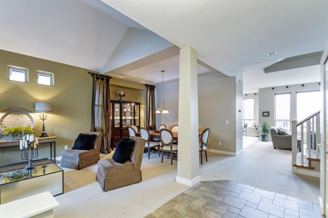 Living area with stairway, baseboards, light carpet, and stone finish flooring | Image 5