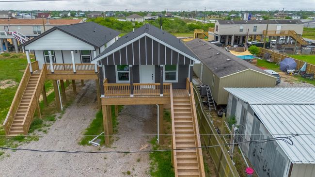 A striking aerial perspective highlights the home’s elevated profile and bold contrast in exterior finishes, with the front porch crowning the staircase and beckoning guests toward the entry. | Image 31
