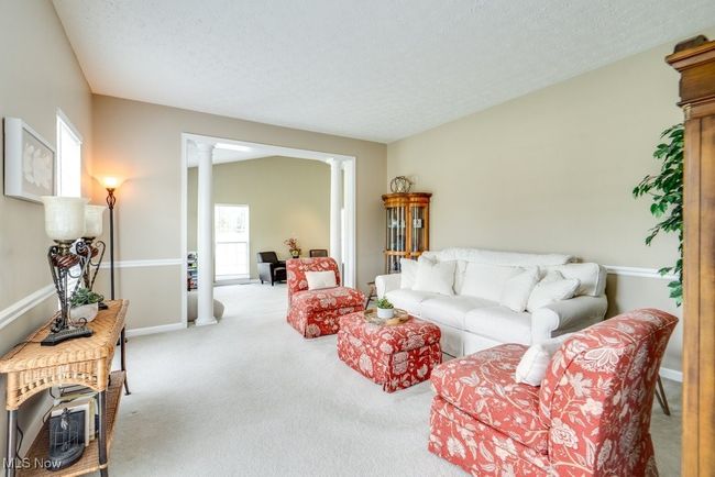 Carpeted living room featuring decorative columns and a textured ceiling | Image 17