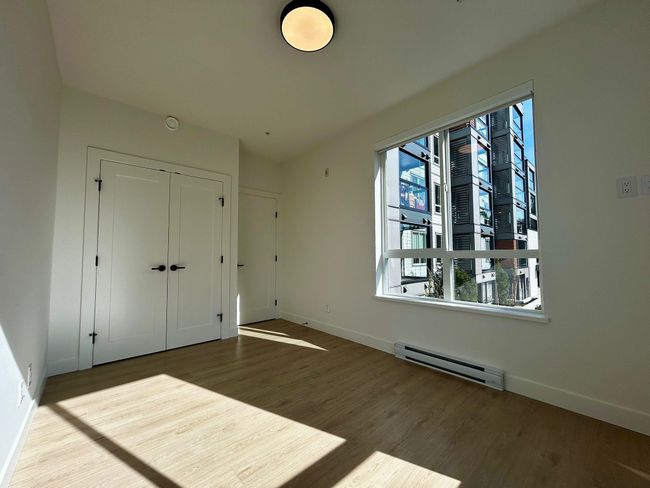 Unfurnished bedroom featuring wood finished floors, a closet, a baseboard heating unit, and baseboards | Image 9