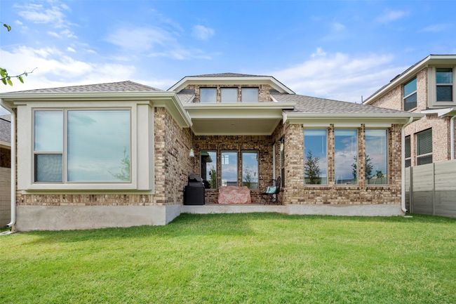 Rear view of property with a yard, brick siding, and roof with shingles | Image 36