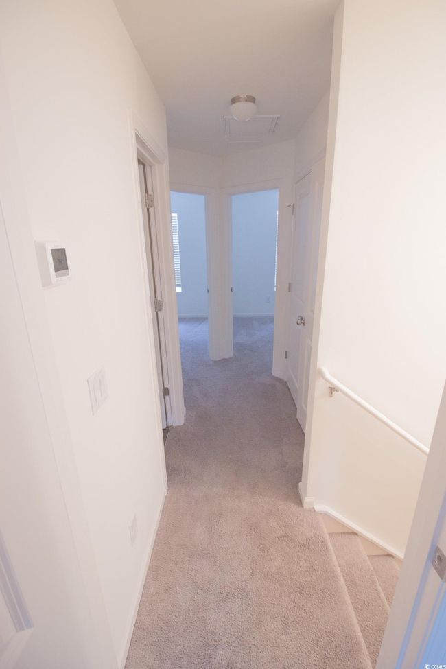 Hallway with light colored carpet and baseboards | Image 10